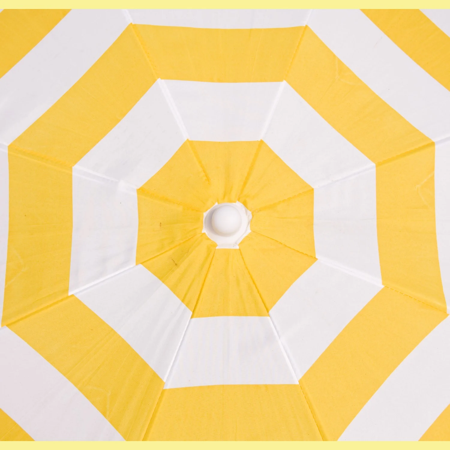 Un parasol à rayures jaunes et blanches vu du dessous