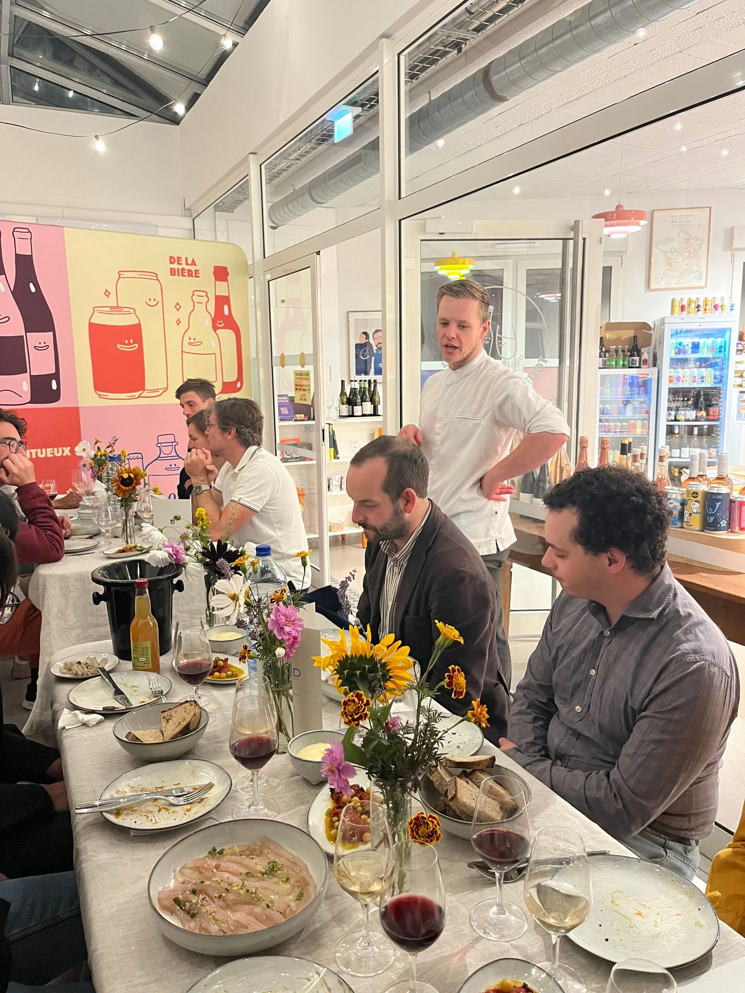 Le chef Julien Schaffhauser présente le dîner aux convives attablés sous la verrière de la cave