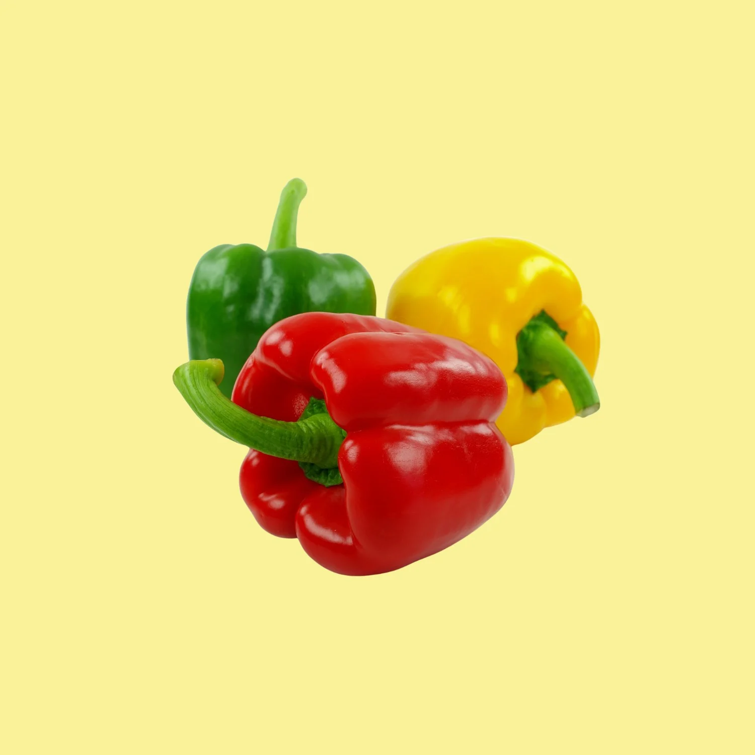 Trois poivrons, rouge, jaune et vert, sur fond jaune